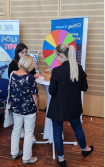 Besucher des Seniorentages beim Drehen des Glücksrads